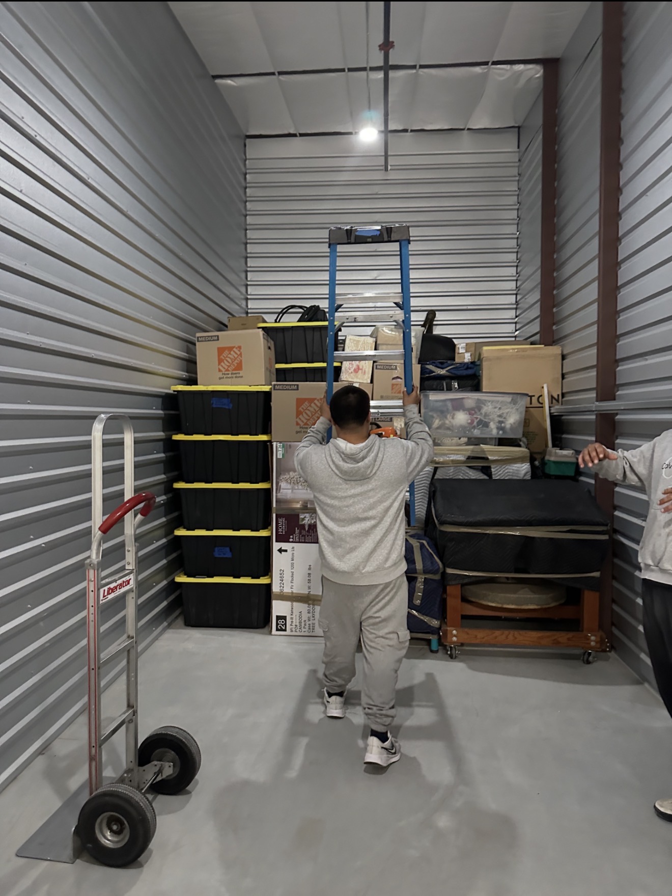 Gio loading a storage unit with labeled boxes and totes for a Kyle, TX customer